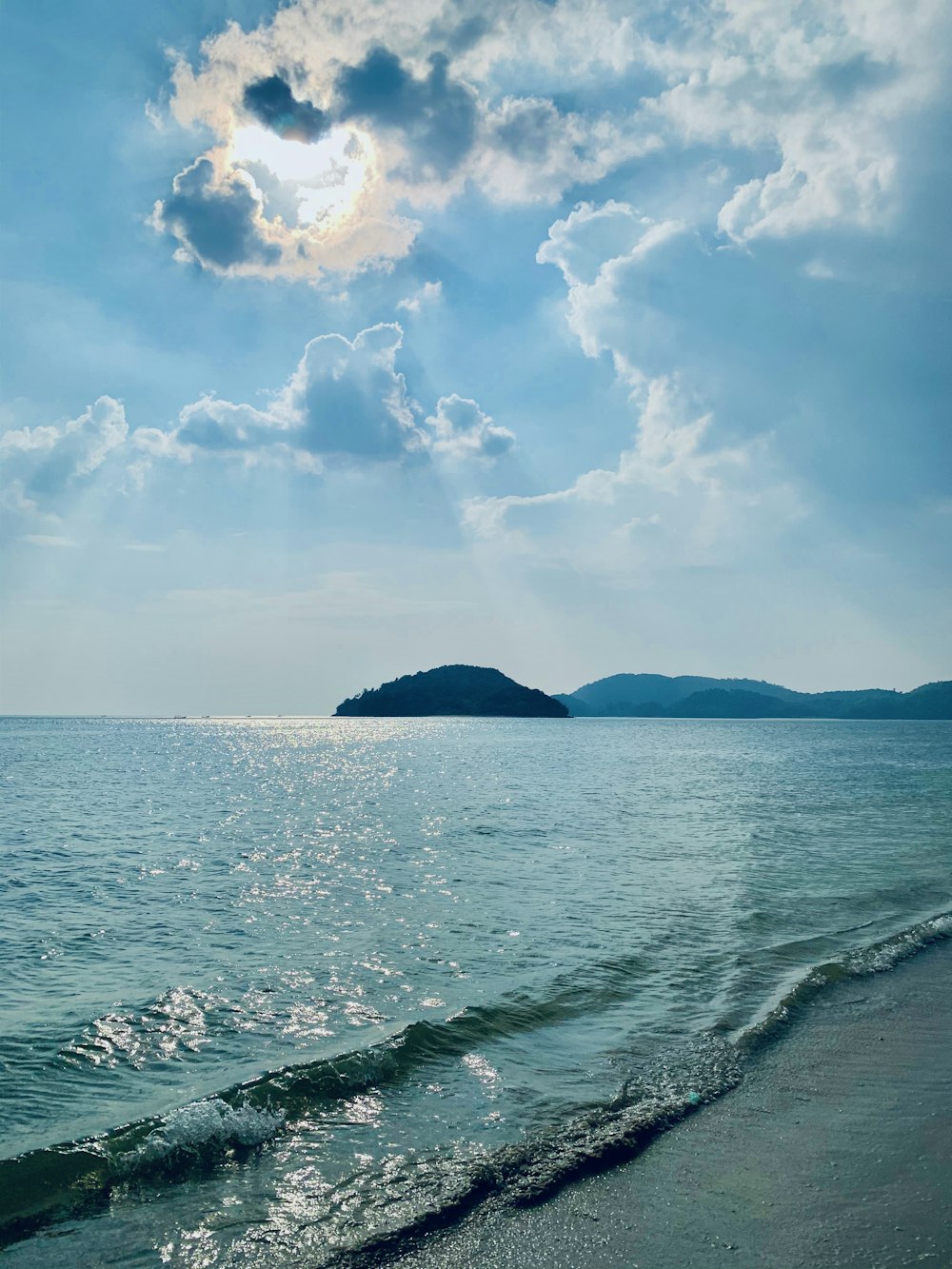 mar azul sob céu azul e nuvens brancas durante o dia