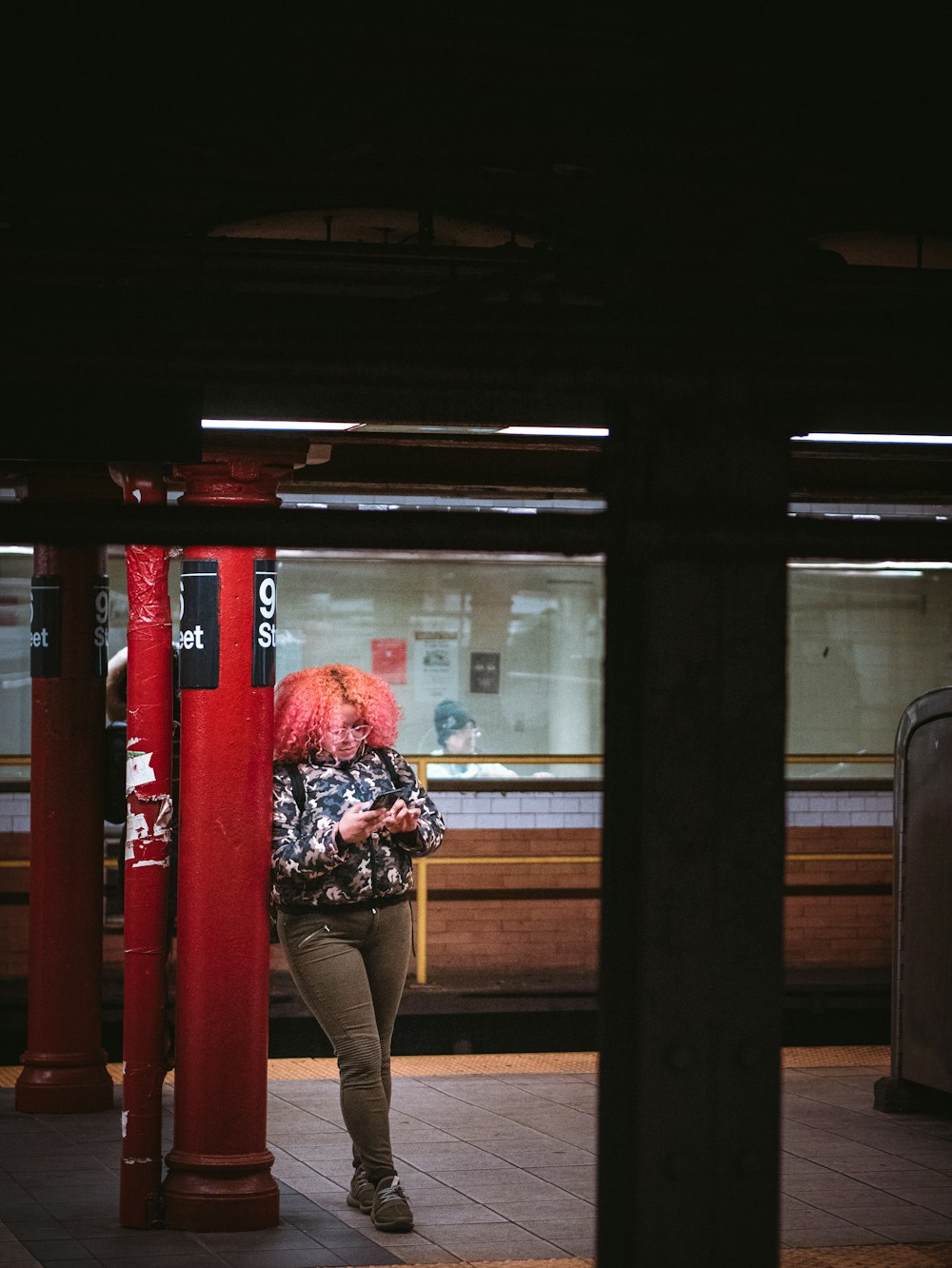 woman in red and white floral long sleeve shirt sitting on brown wooden bench