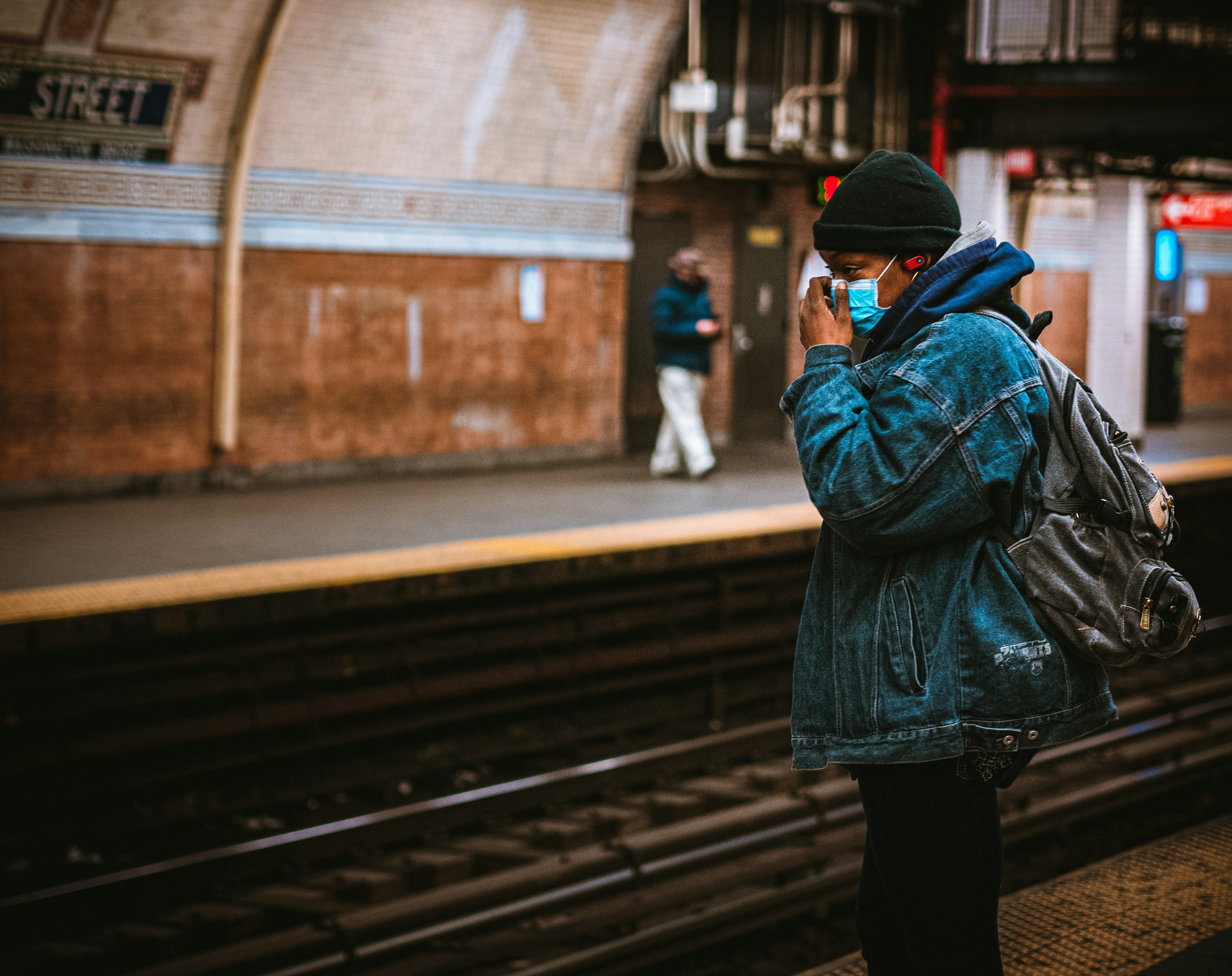 woman in black jacket and black pants standing on train rail during daytime