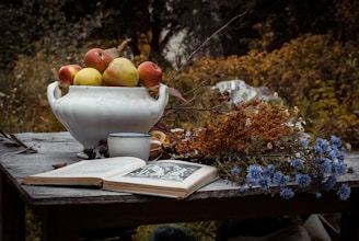 A rustic wooden table set with seasonal vegetables and a cozy cookbook open.