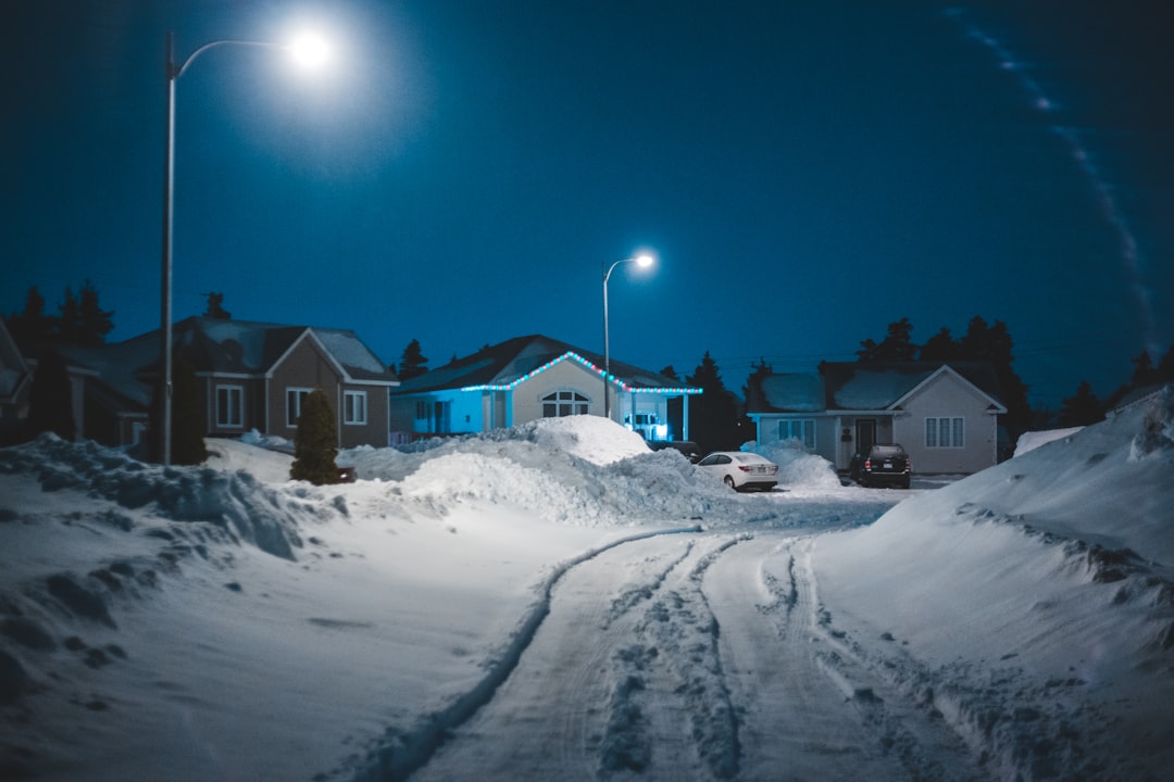 brown and white house on snow covered ground under blue sky during night time