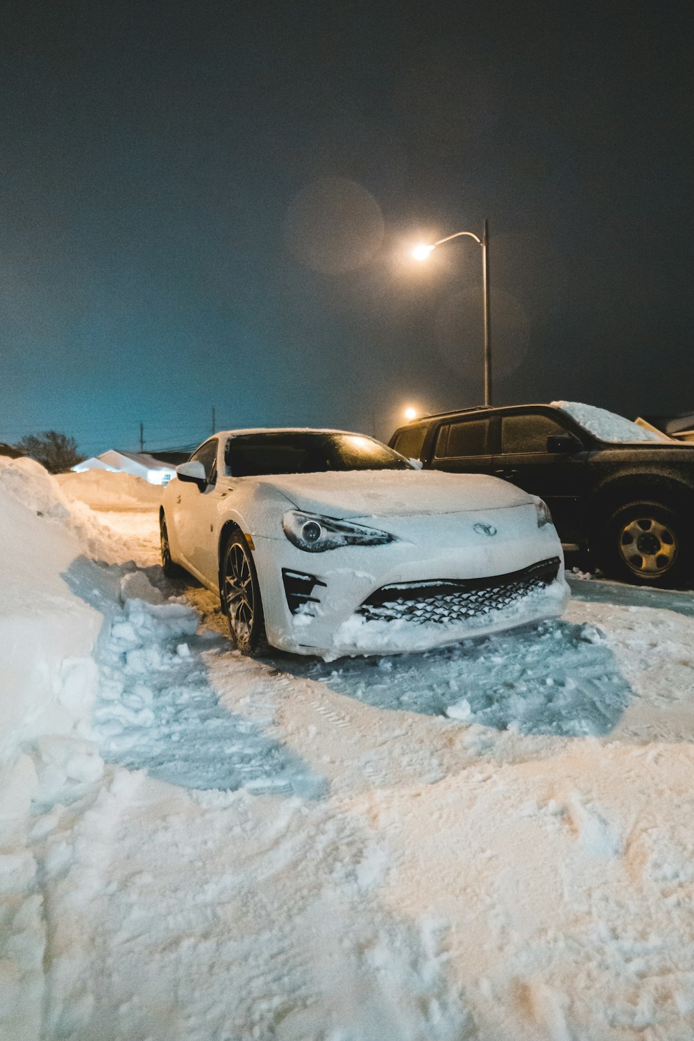 white and black chevrolet camaro on snow covered ground during night time