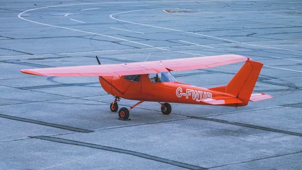 red and white airplane on gray concrete ground during daytime