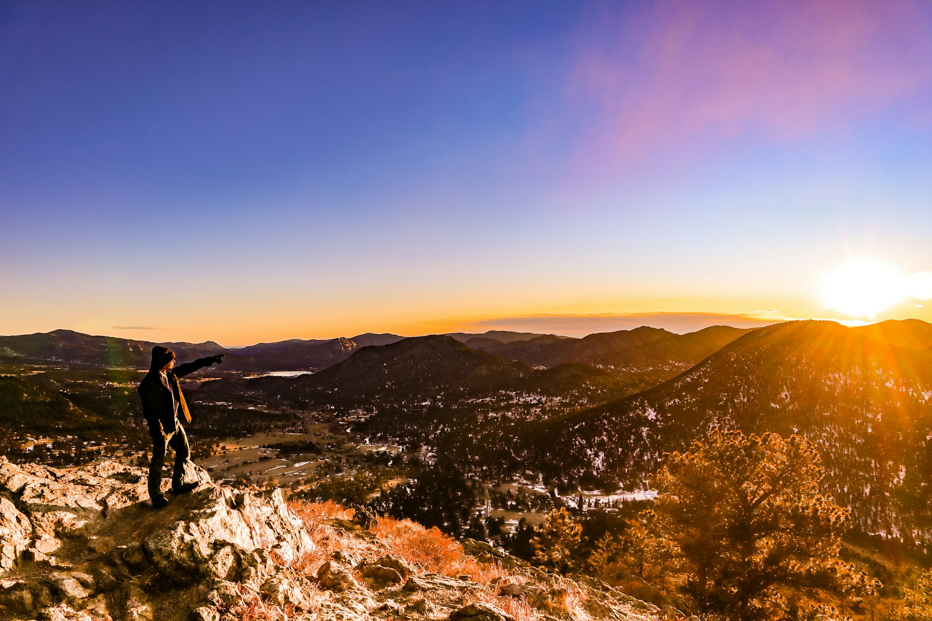 Trail runner on a rocky ridge above the Colorado high country at sunrise