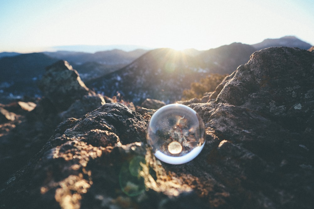 clear glass ball on brown rock