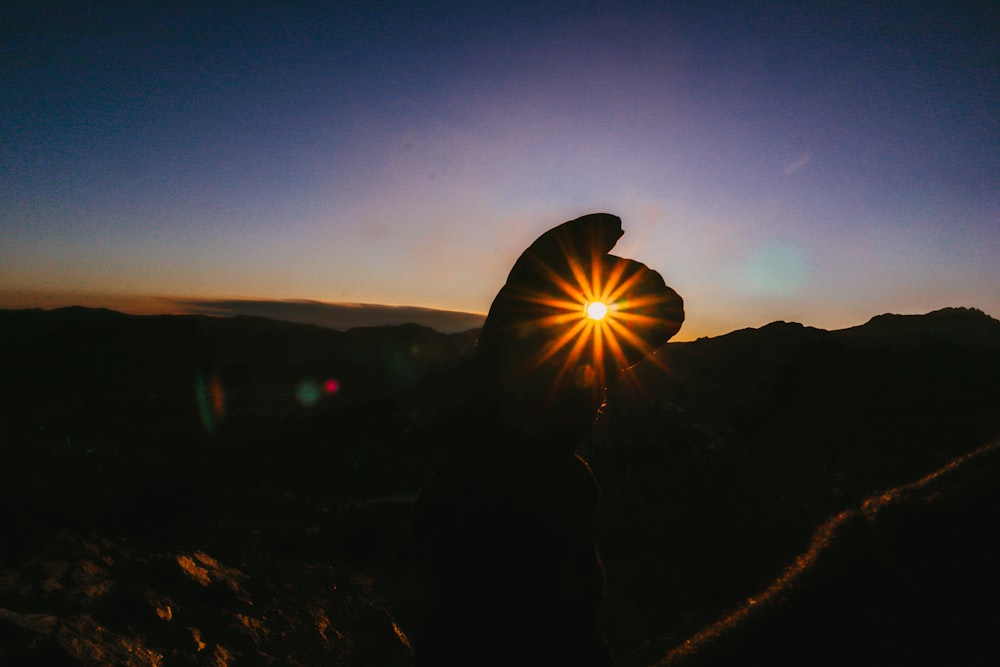 silhouette of person wearing hat during sunset