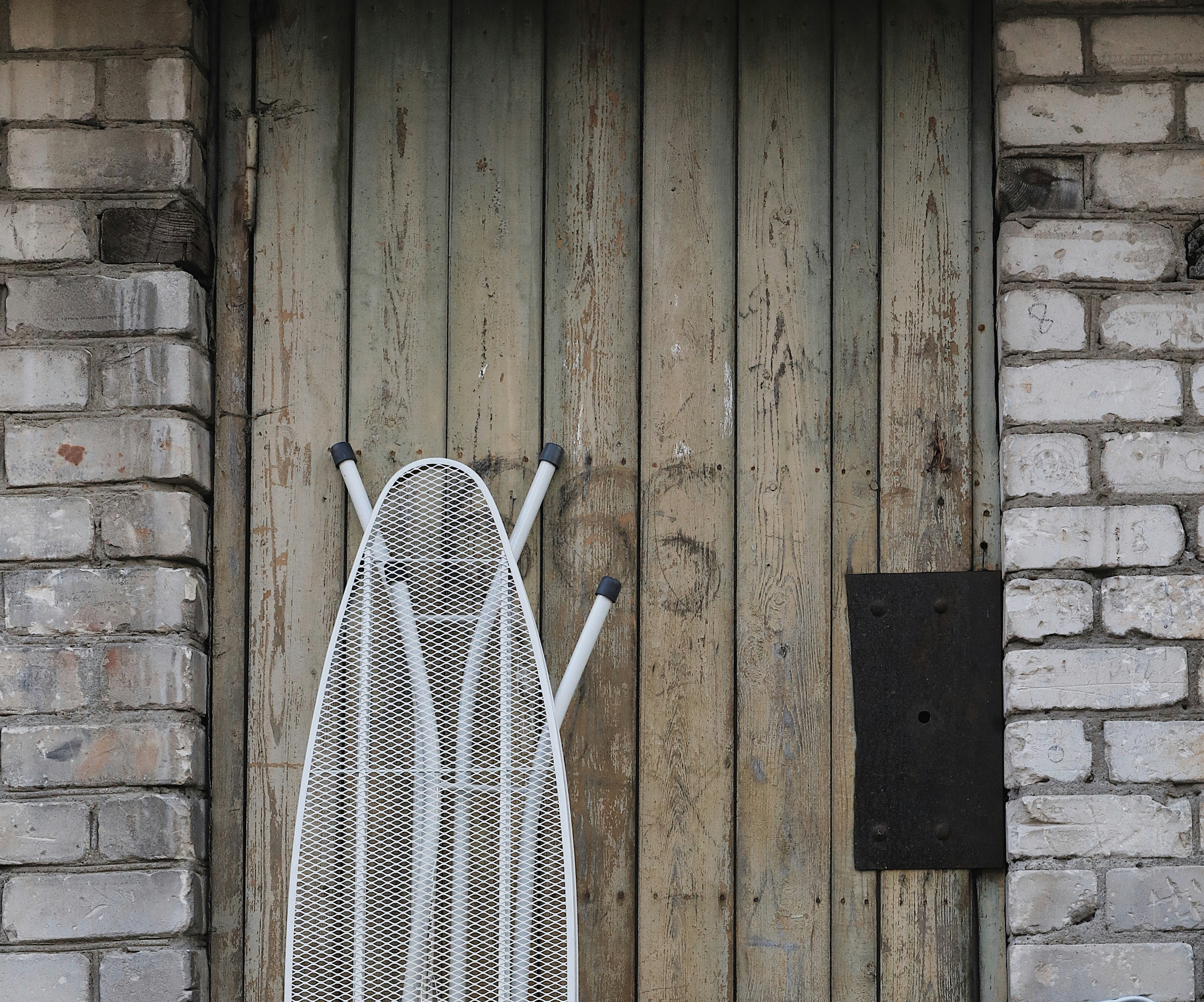 white and black striped chair beside brown wooden wall
