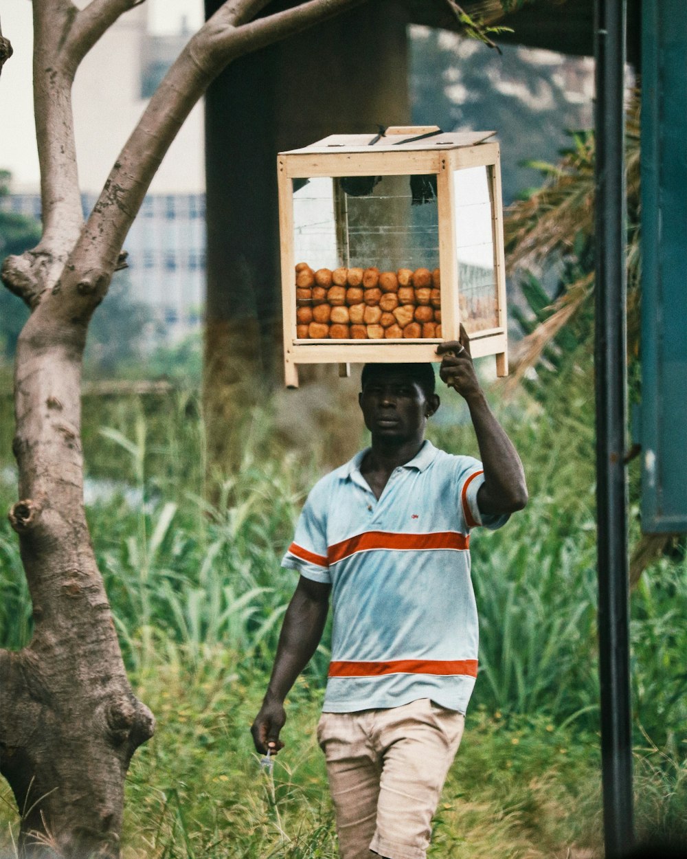 man in white and orange jersey shirt holding brown wooden box