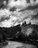 A dramatic black and white photo of an ancient castle shrouded in mist.