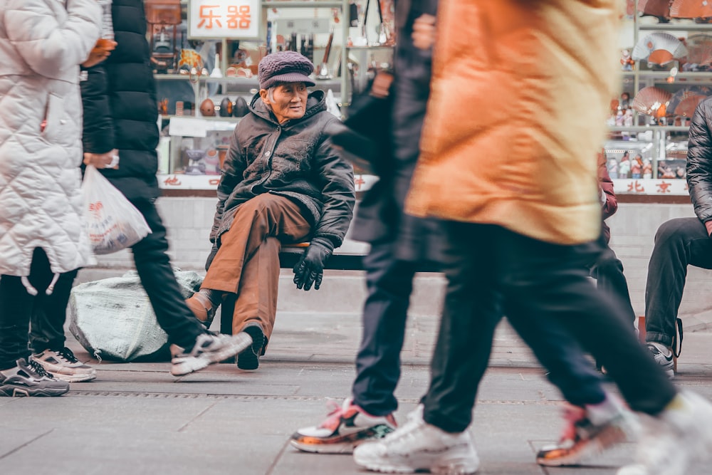 man in black leather jacket and black pants walking on sidewalk during daytime