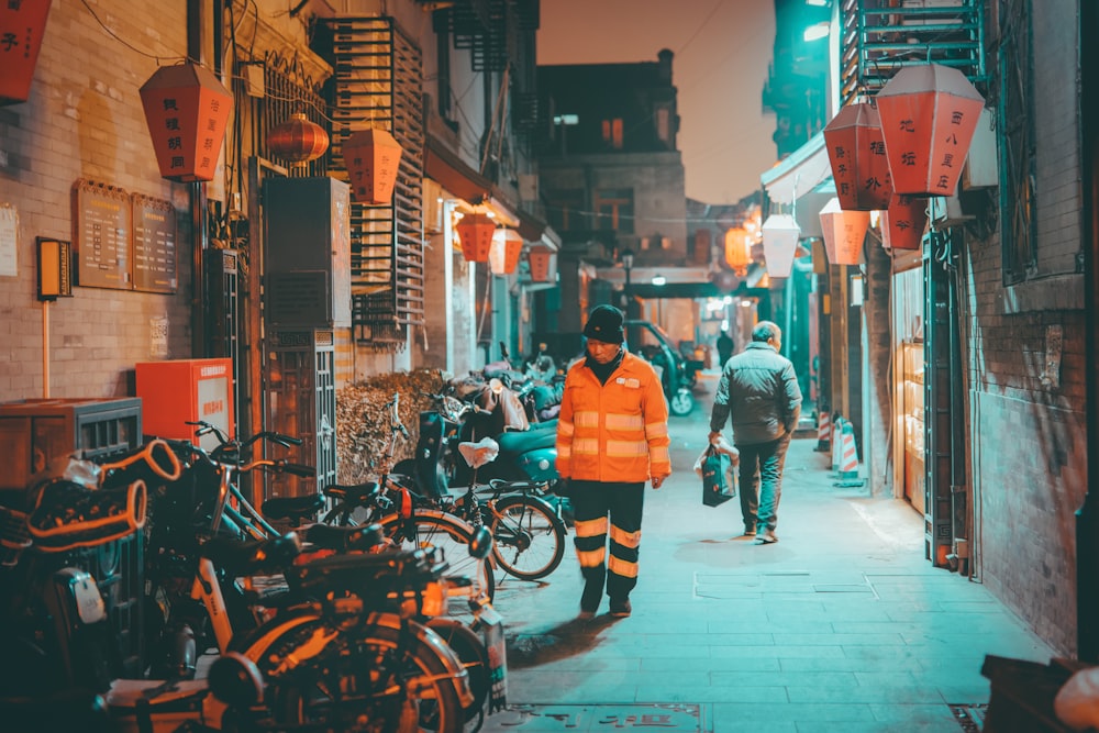 man in yellow jacket standing beside black motorcycle during daytime