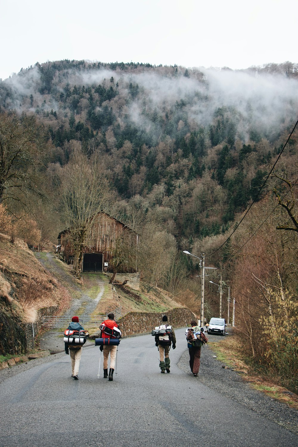 people walking on road near brown wooden house during daytime