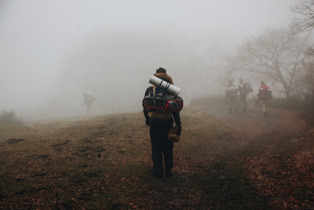 man in black jacket carrying black and white backpack