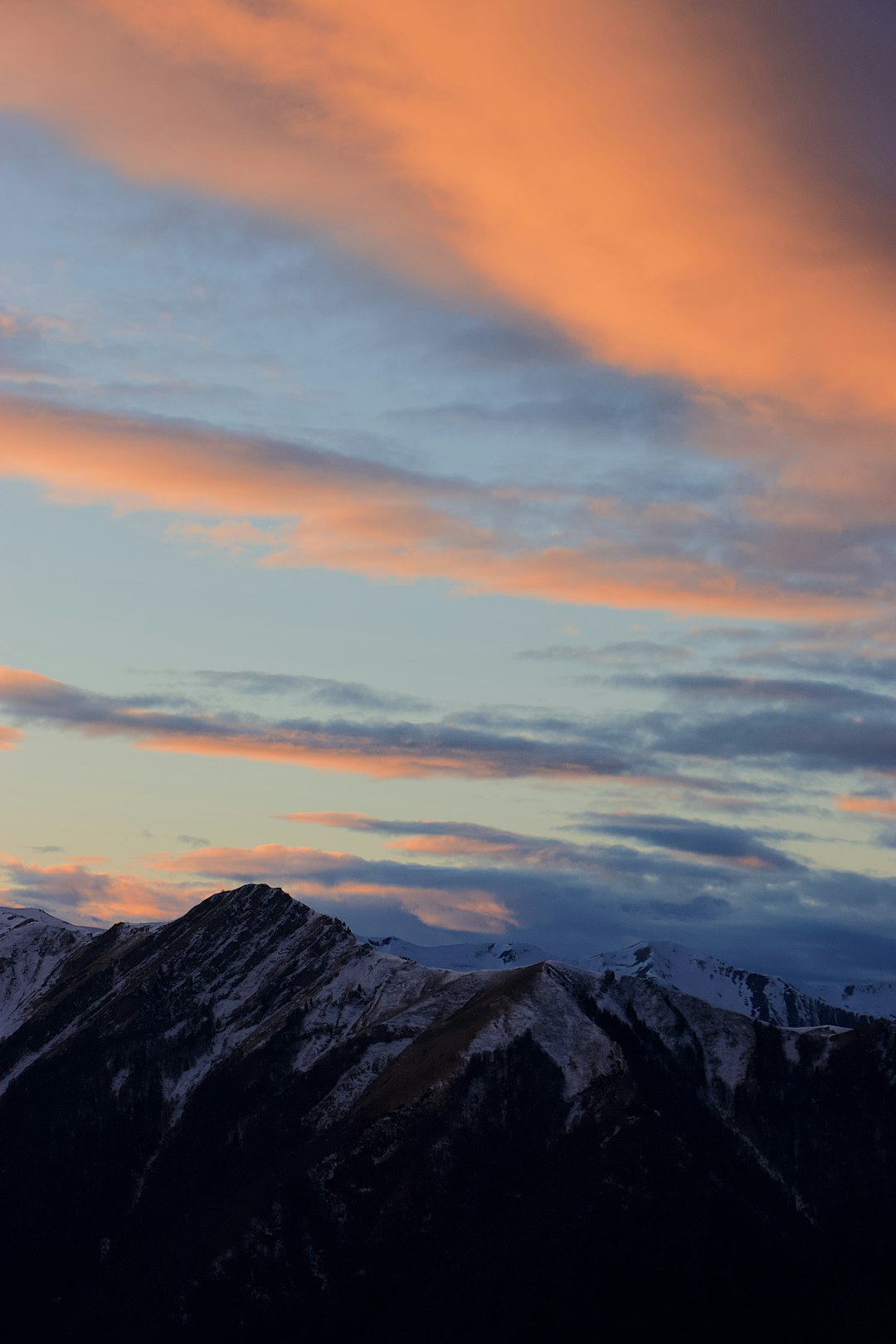 black and white mountains under orange and blue sky