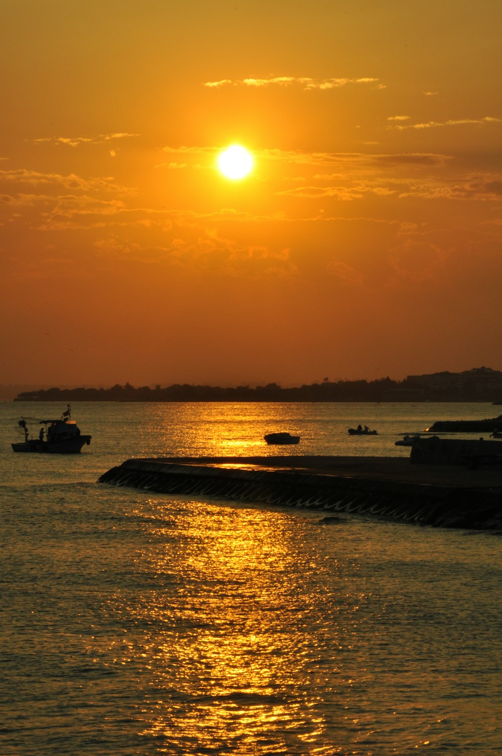 silhouette de bateau sur la mer pendant le coucher du soleil