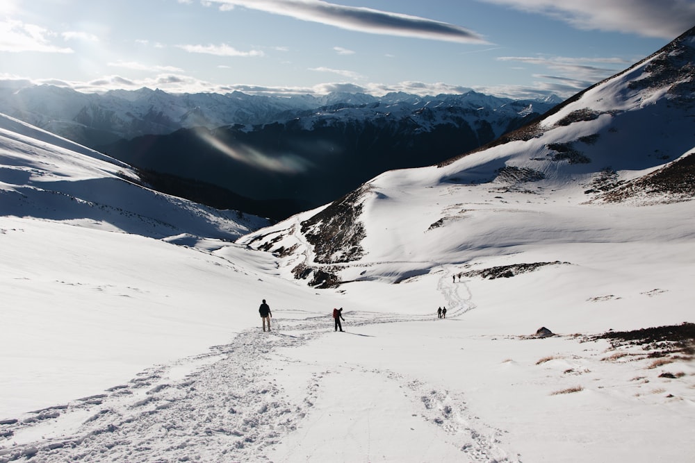 person walking on snow covered mountain during daytime