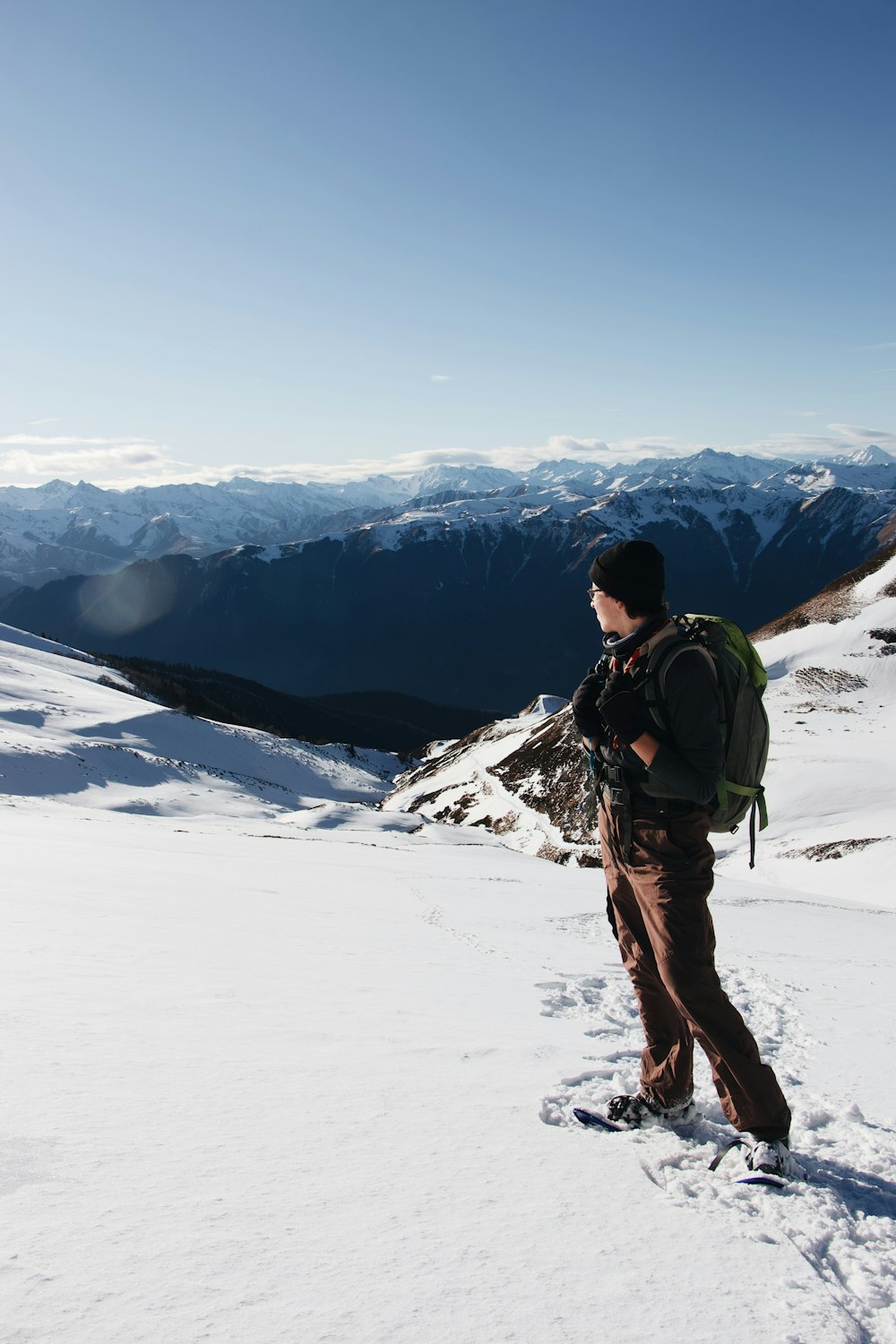 man in black jacket and brown pants standing on snow covered ground during daytime