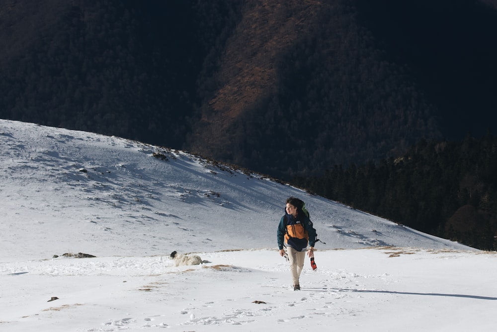 woman in black jacket walking on snow covered field during daytime