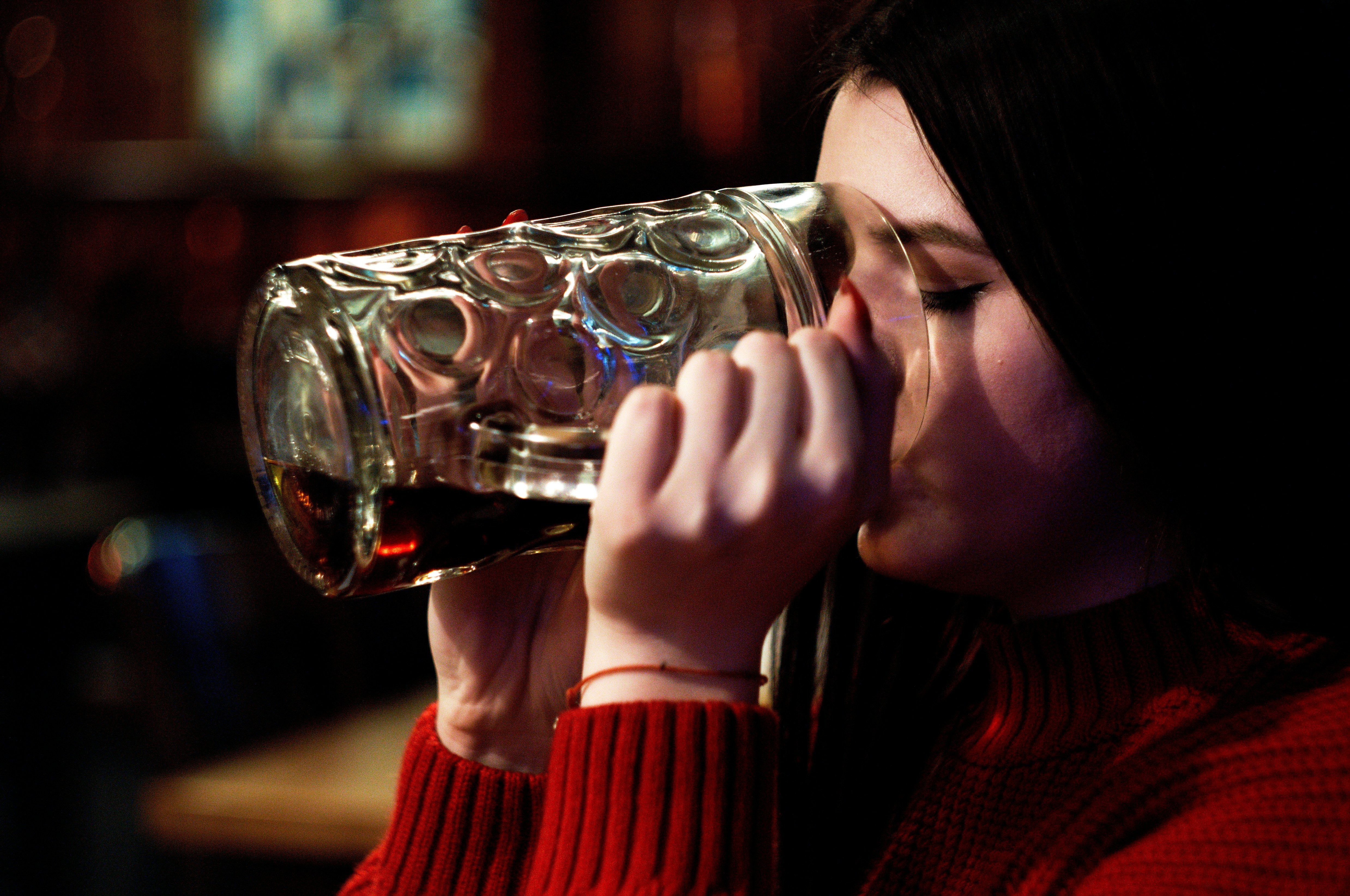 woman in red sweater drinking water