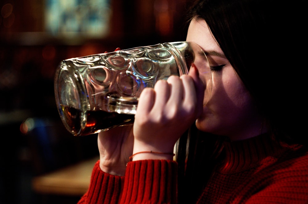 woman in red sweater drinking water