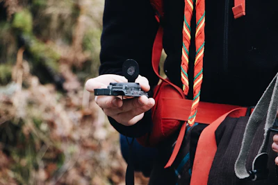Instructor demonstrating map and compass reading on a forest trail.
