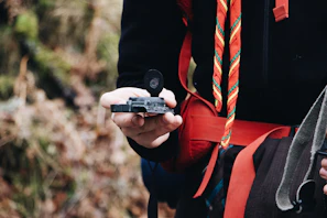 A scout leader guiding a group through an outdoor navigation exercise with maps and compasses
