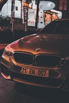 BMW 7 Series in metallic silver, illuminated by soft golden street lamps in an urban setting.