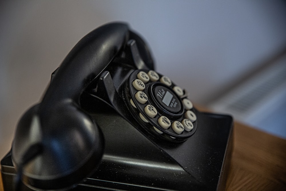 black rotary telephone on black table