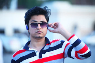 A lifestyle photo showing someone using Ray-Ban Meta glasses while jogging in a park, with earbuds visible.