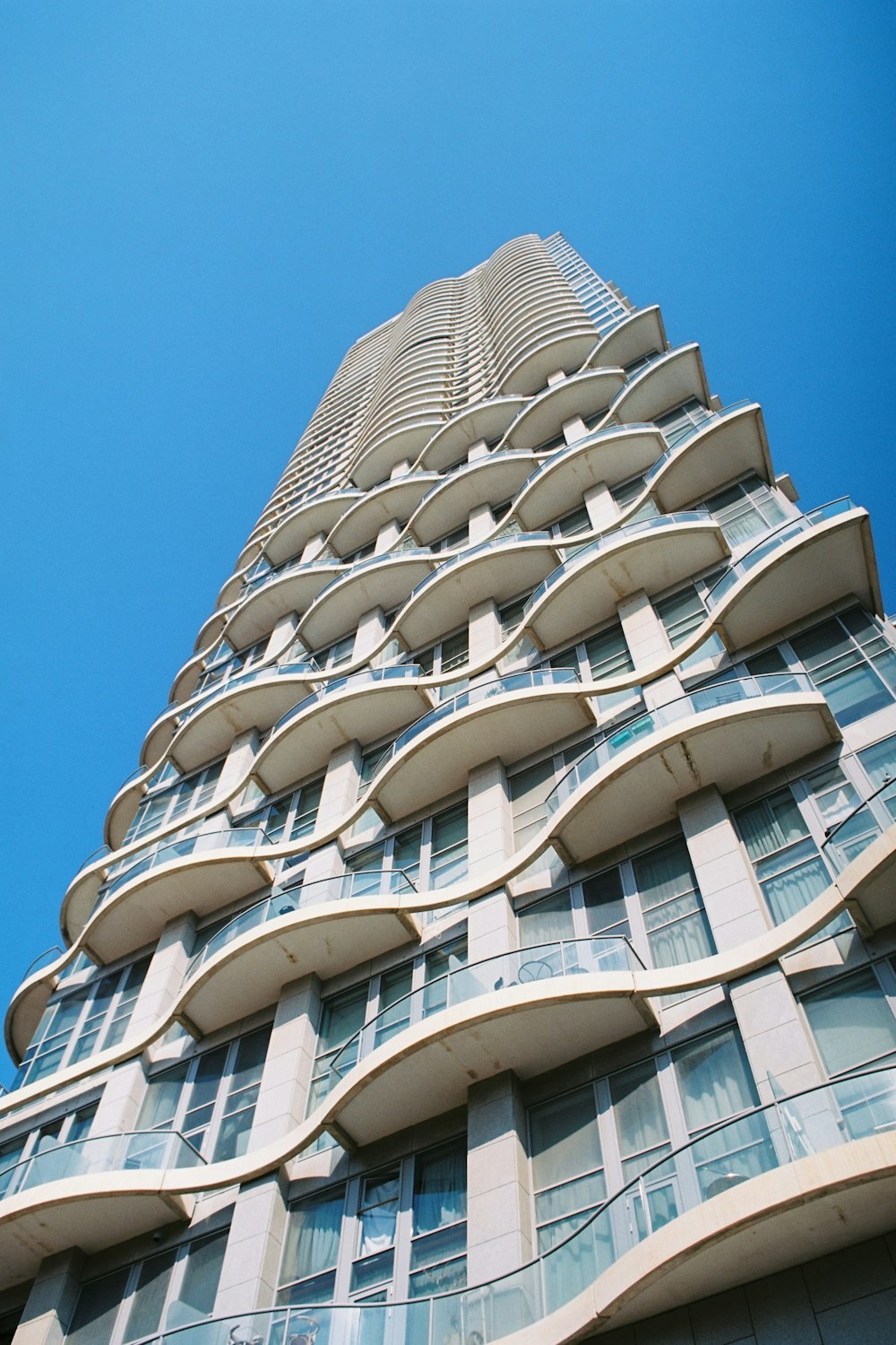 Weißes Betongebäude tagsüber unter blauem Himmel