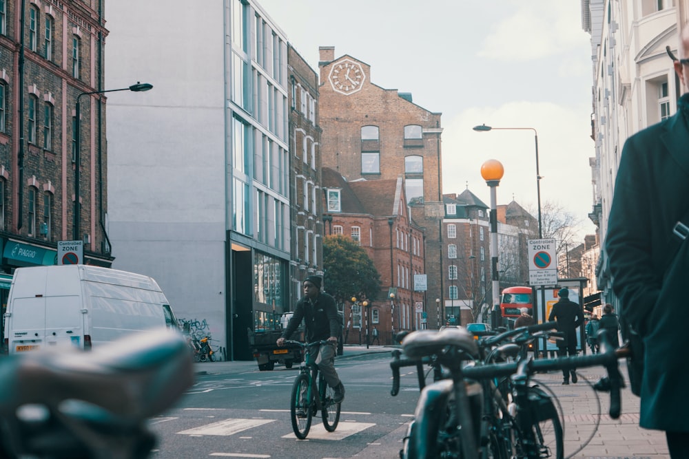 man in black jacket riding bicycle on road during daytime