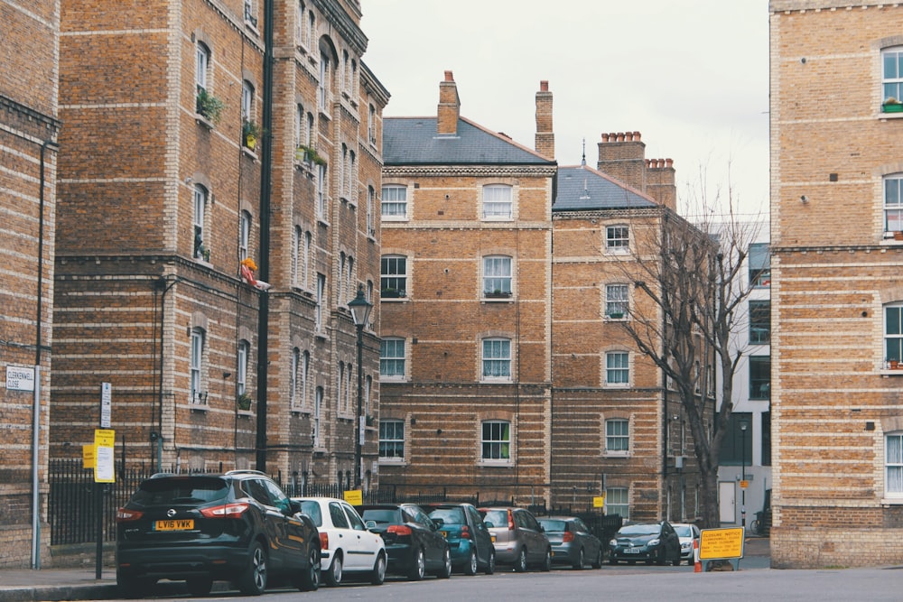 cars parked in front of brown building during daytime