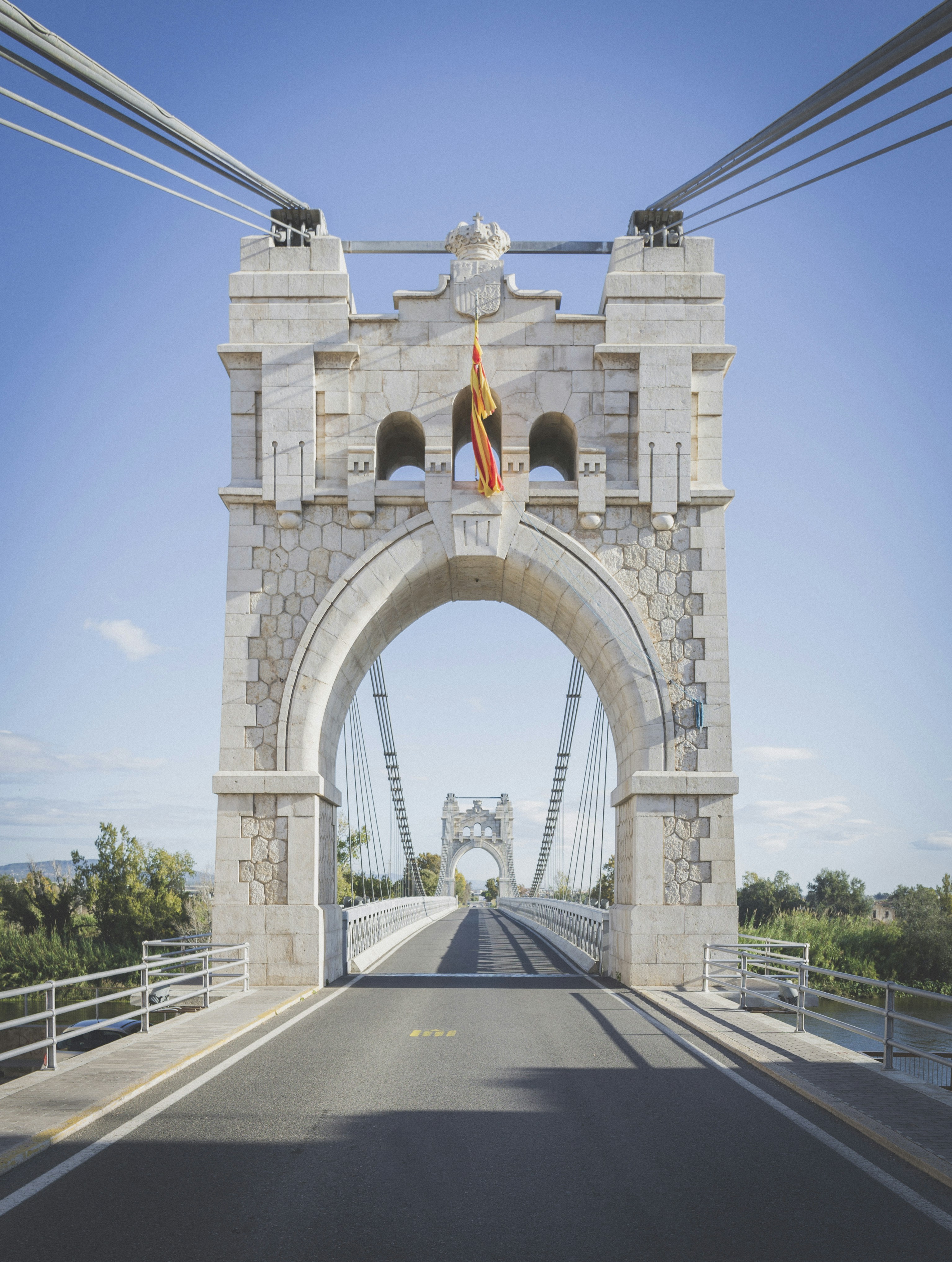 mulher no vestido amarelo que está na ponte de concreto cinzenta durante o dia