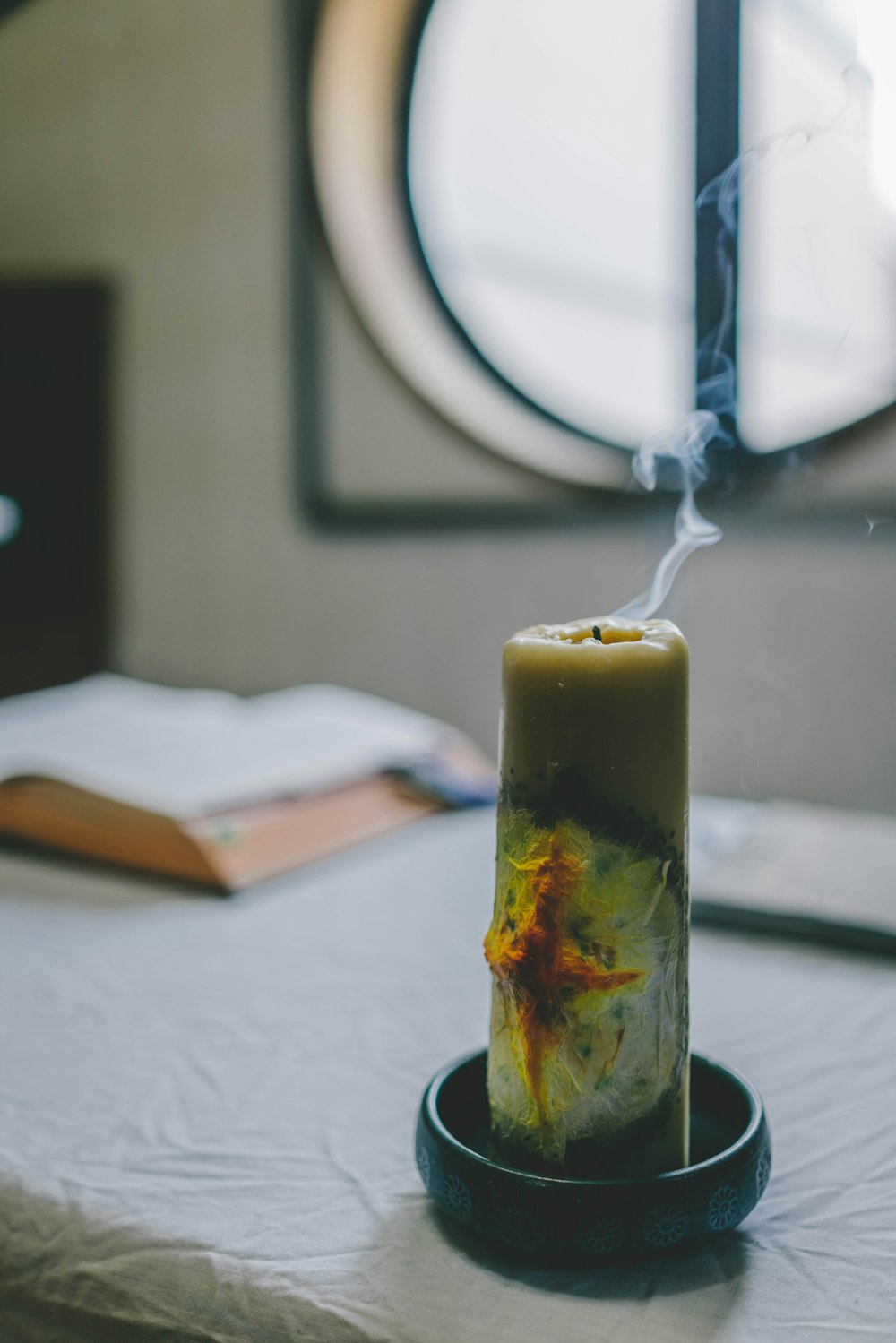 yellow pillar candle on black holder