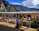Smiling traveler standing in front of colorful Tibetan temples during the Rebgong festival