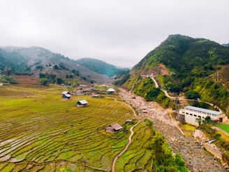 Terraced rice fields cascading down the slopes near Sapa, with ethnic minority villagers walking along narrow paths.