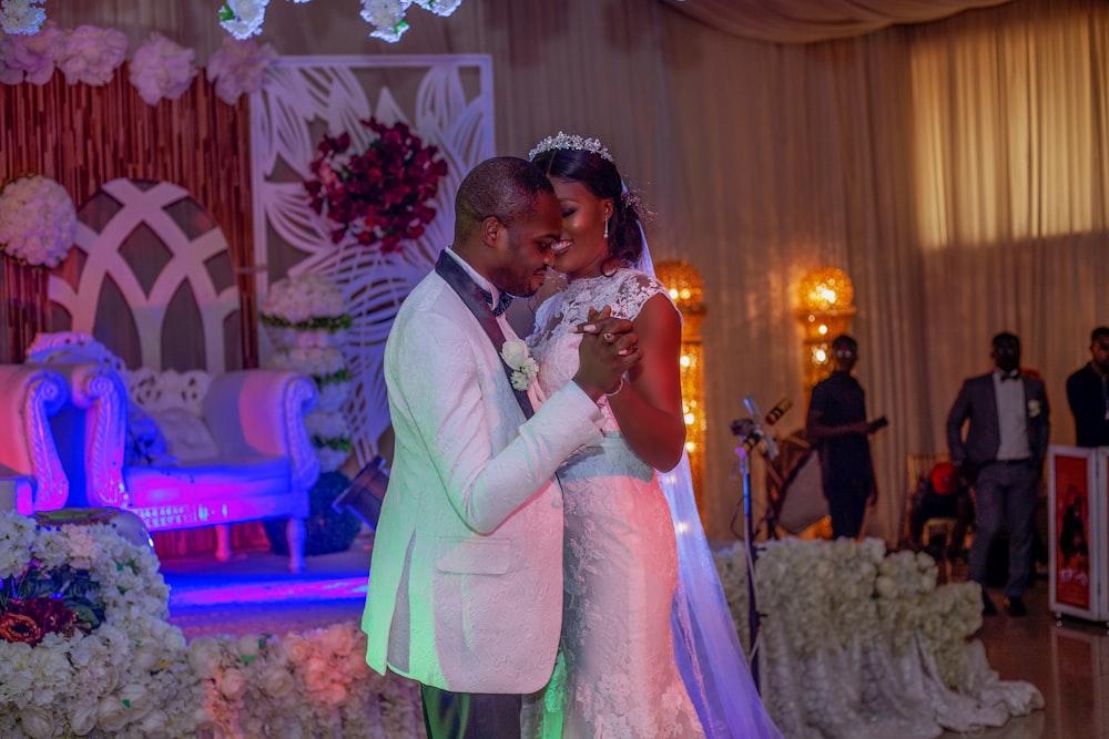 man in gray suit kissing woman in white wedding dress