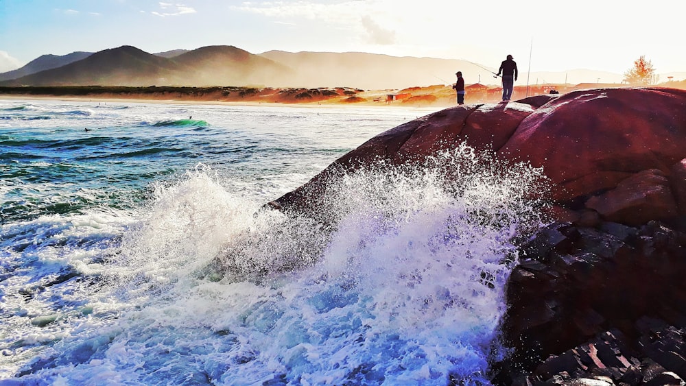 man in black wet suit surfing on sea waves during daytime