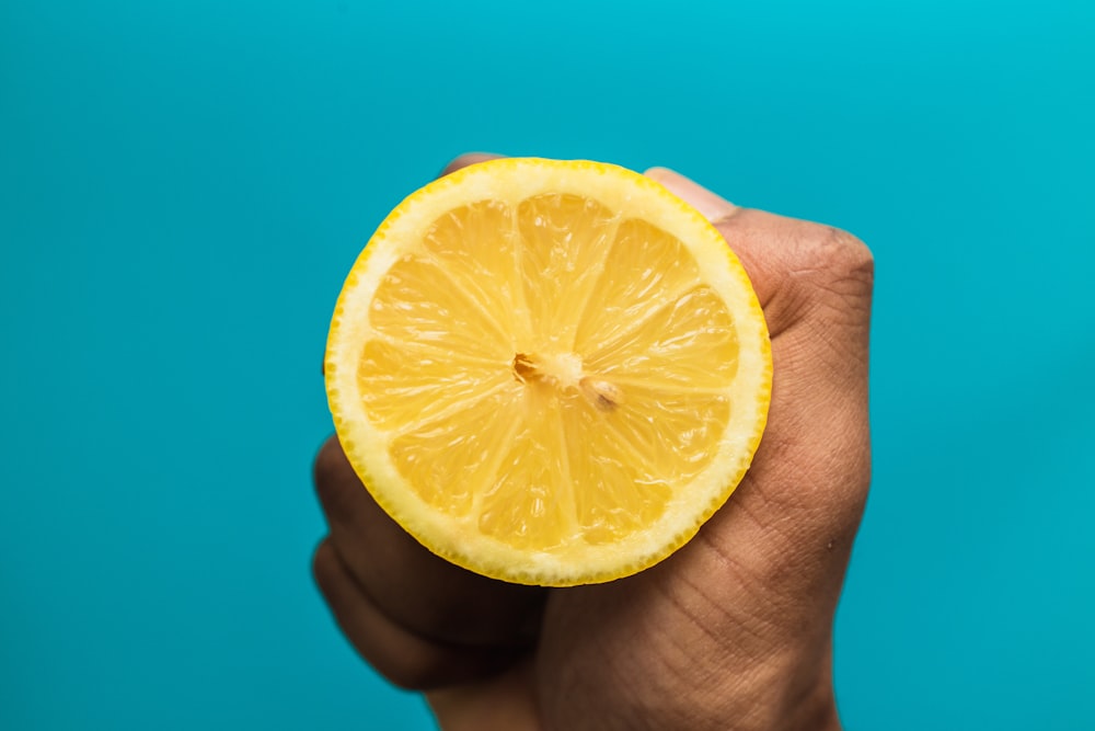 person holding sliced lemon fruit