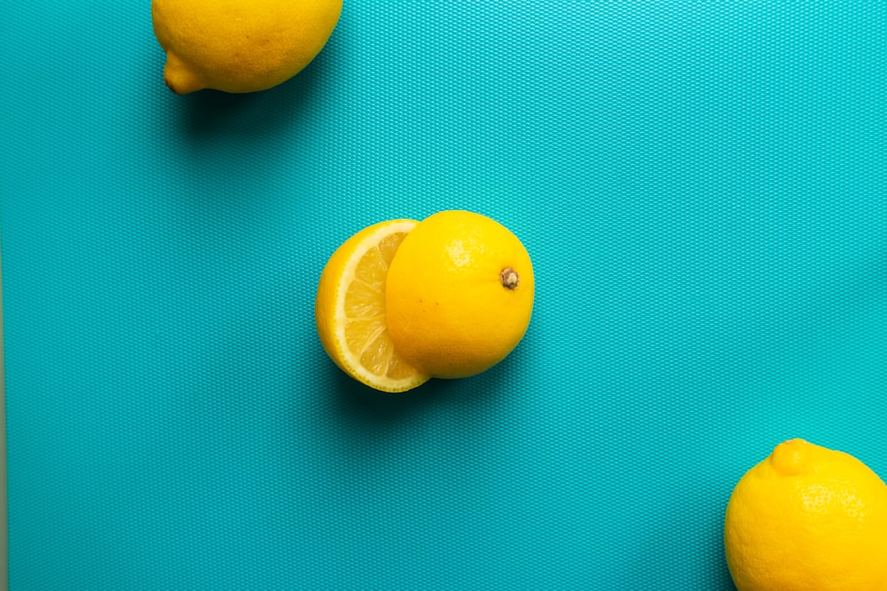 two yellow lemon fruits on blue surface