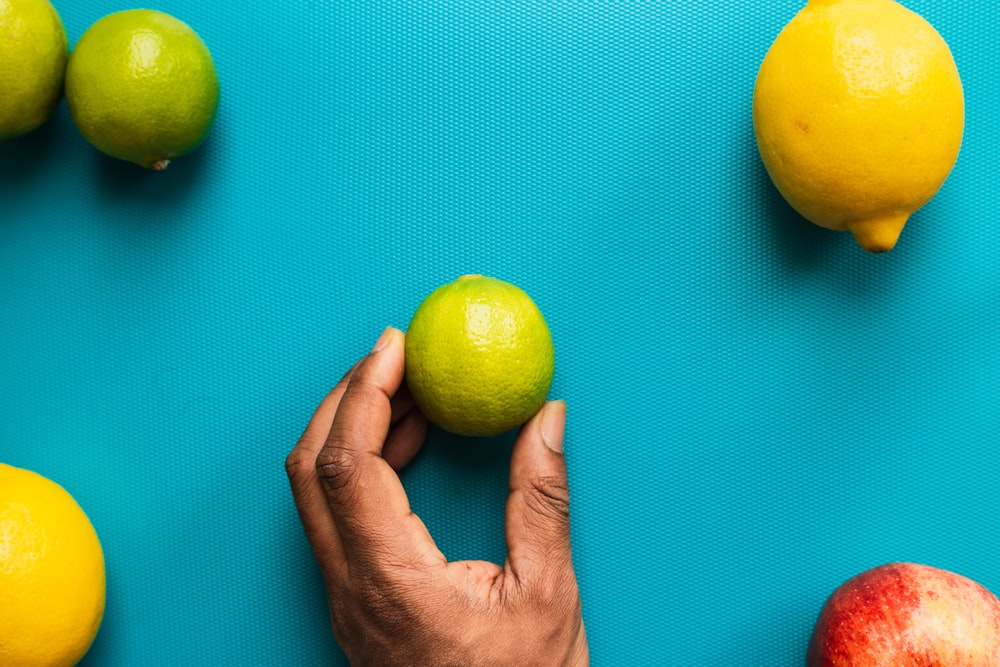 pessoa segurando fruta de limão amarelo