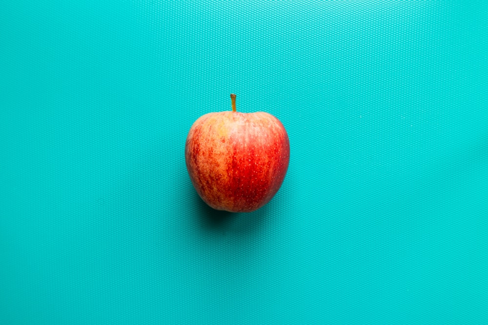 Manzana roja sobre superficie azul