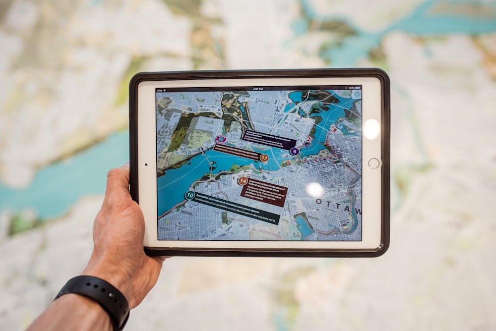 person holding white ipad with black case