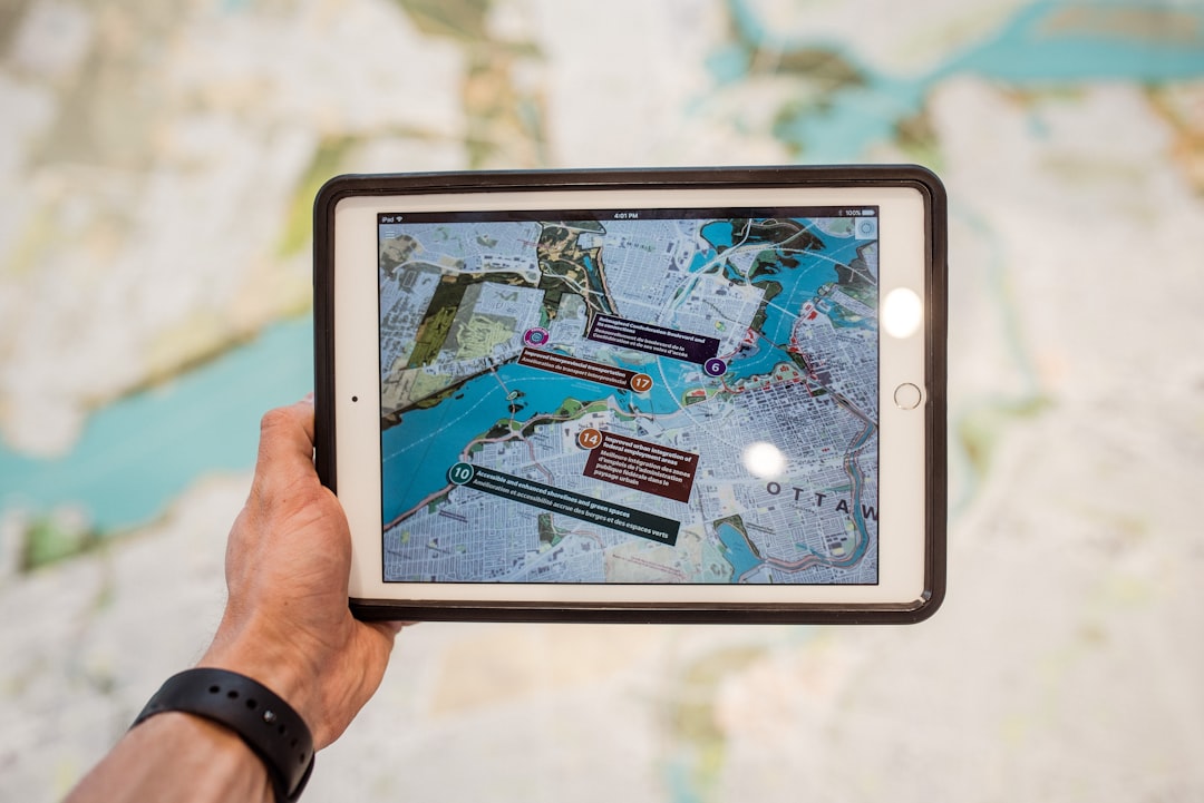 person holding white ipad with black case,