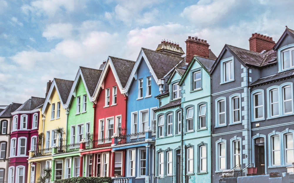 Edificios de hormigón verde, rojo y blanco bajo nubes blancas y cielo azul durante el día