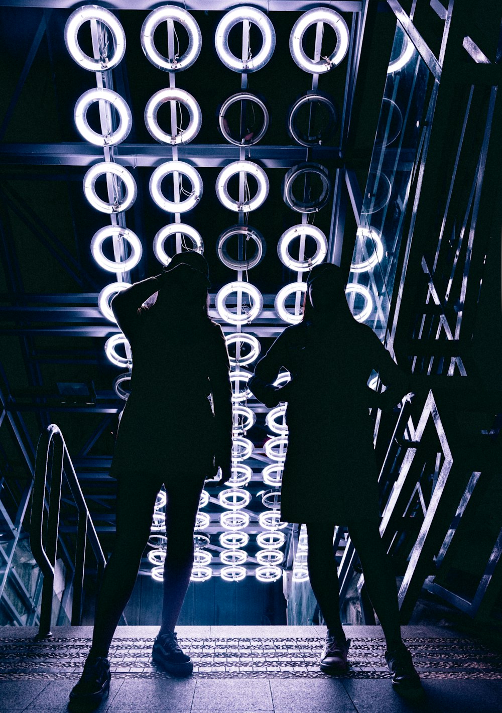 man in black jacket standing beside white neon light signage