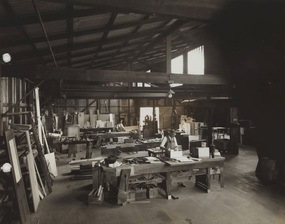 grayscale photo of people sitting on chair inside building