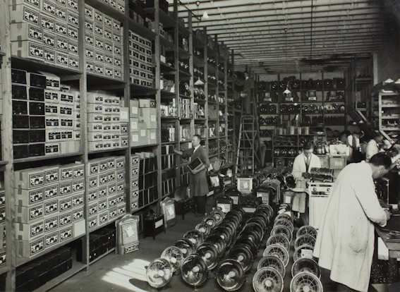 Stacks of laptops and electronic gadgets ready for shipment in a modern warehouse.