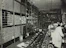 Stacks of electronic gadgets and components neatly organized on steel shelves in a warehouse.