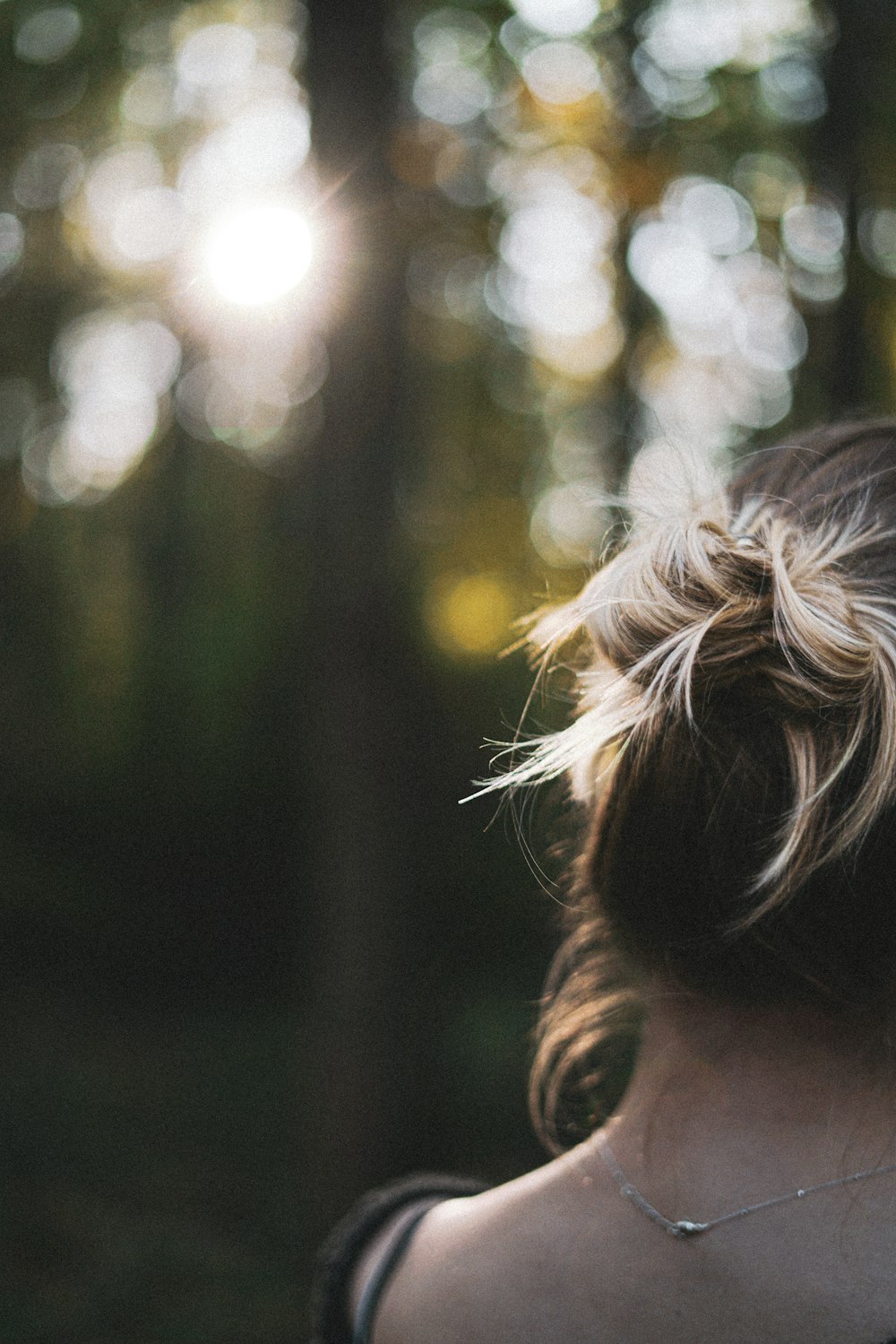 a woman with a messy bun in a forest